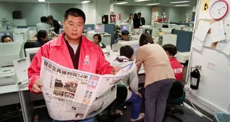 Jimmy Lai reading his newspaper