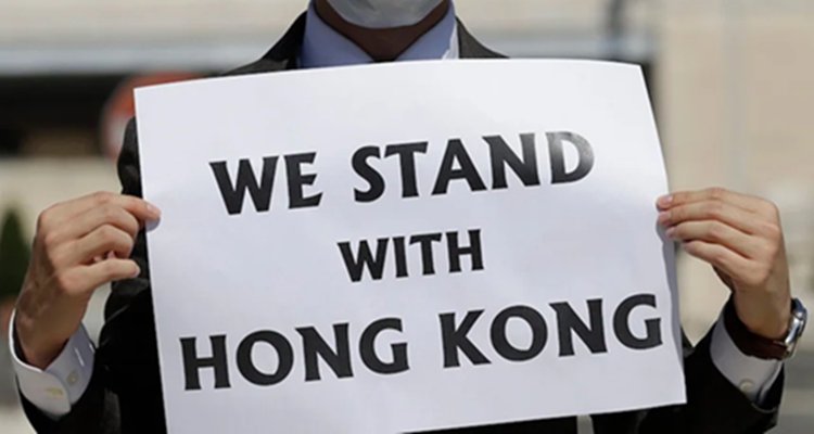 Man holding sign saying We Stand With Hong Kong