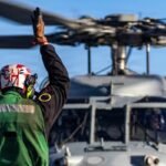 U.S. Navy sailor signaling a helicopter during Operation Epic Fury