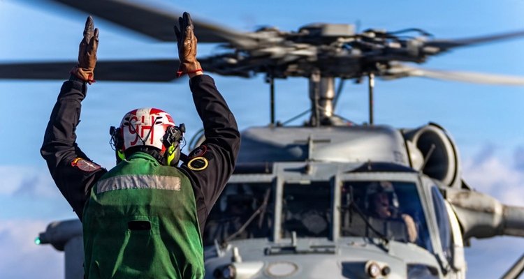 U.S. Navy sailor signaling a helicopter during Operation Epic Fury